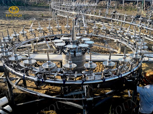 Large metal circular structure with multiple arms in an outdoor setting