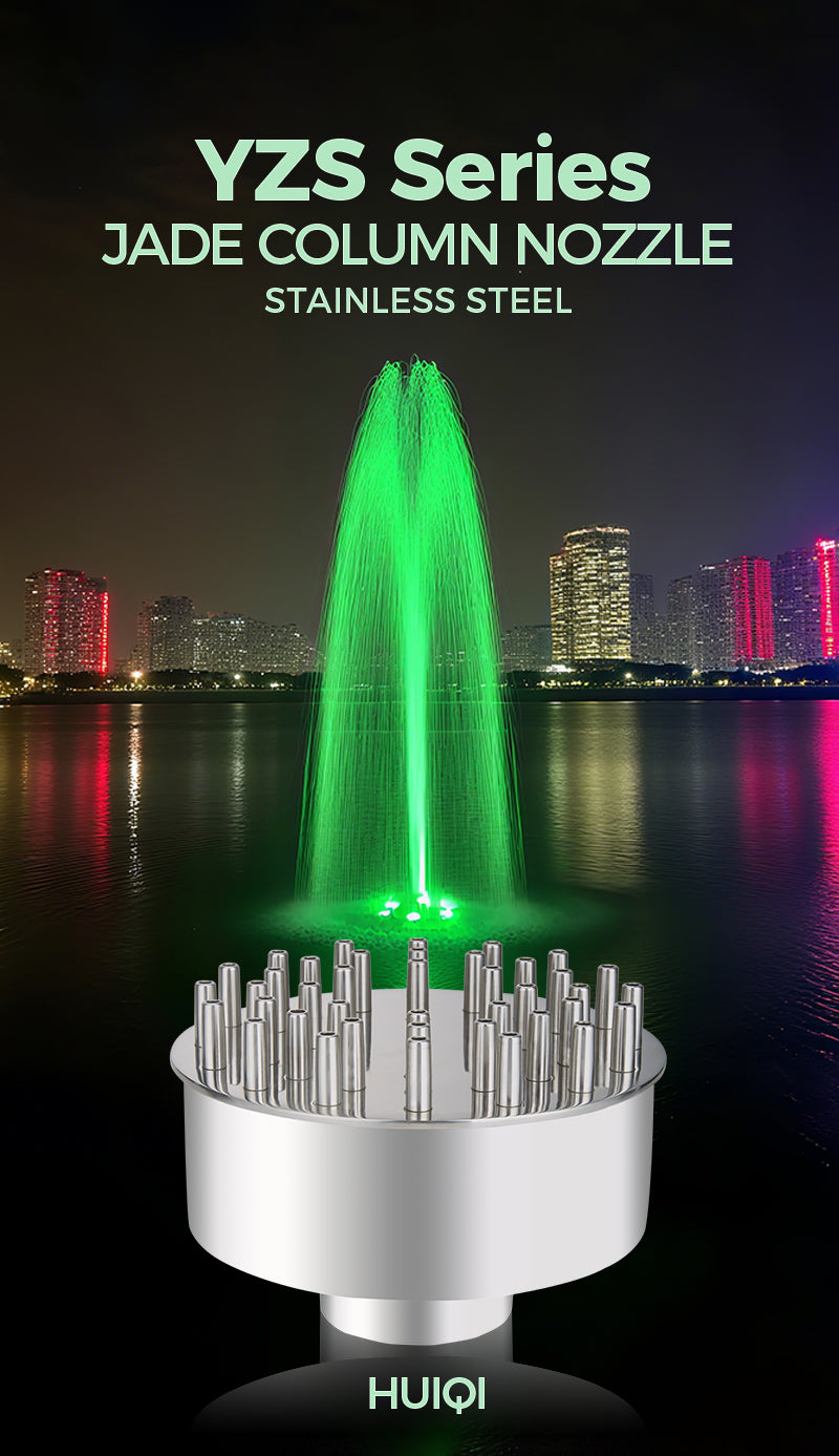 Jade column nozzle with green water spray in front of a city skyline at night.